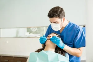 Dentista masculino examinando boca paciente