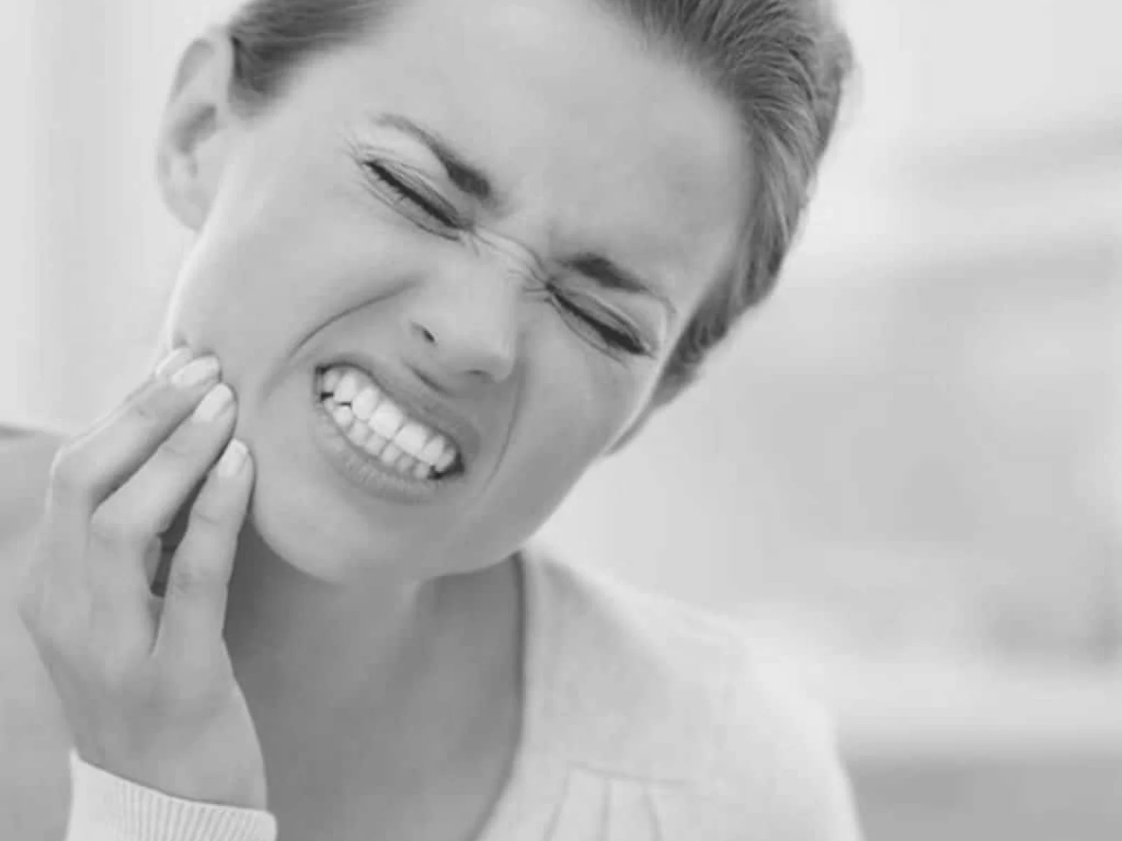 Mujer con dolor en la mandíbula a causa del bruxismo